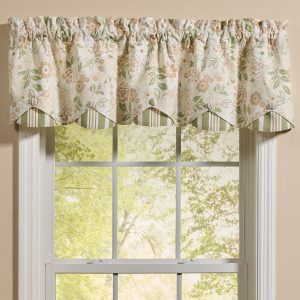 Valance curtain with a scalloped edge in a soft delicate floral with a striped lining peeping out under the scalloped edge.