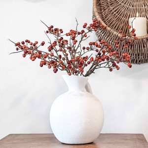 Orange berry pod sprays in white jug